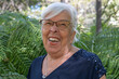 © luciano - Senior adult woman laughing cheerfully with her mouth open. Expressing genuine happiness and a wise