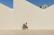 © valbar STUDIO/Stocksy - kid Walking Along a Wall in a City