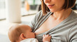 © Irina Kado - Breastfeeding in public showing a young mother nursing her baby in a bright indoor setting. This image represents motherhood, childcare, and nursing in public spaces.
