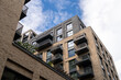 © MarshallChan - Modern Urban Apartment Building Exterior With Balconies Against Cloudy Sky