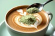 © starush - Latte with matcha powder being sprinkled over milk foam heart in cup on saucer