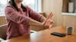 © Таня Андреева - Woman stretching wrists at desk for office wellness and health.
