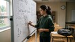© Николай Срибяник - Young female student solving calculus equations on classroom whiteboard with focused expression.