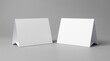 © Linda - Blank table tent cards standing on gray surface with clean studio lighting for restaurant menu and event branding