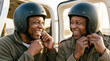 © sergign - Two happy mature african american men fastening aviation helmets before private airplane flight