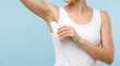 © MUHAMMAD - Young woman maintaining personal hygiene by applying antiperspirant to her underarm for daily freshness and confidence