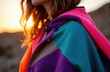 © starush - Woman wearing colorful blanket at sunset outdoors with warm backlight glow