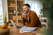 © Miljan Živković - Young man smiling working from home remote office