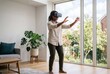 © AdPremium - Young Black woman using a virtual reality headset and interacting with digital content in a bright, modern living room at home