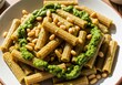 © Georgiy - Rigatoni pasta with pesto sauce and pine nut on plate. Italian traditional cuisine dish. Healthy lunch or dinner meal rich in flavor and nutrition for culinary blog and catering service.