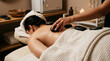 © sakson - Soothing hot stone massage therapy designed to alleviate office syndrome in a tranquil spa setting