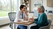 © LangkahKaki - Female doctor in white coat consults with an older female patient in a bright, modern clinic office.