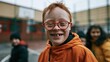 © Studio Zenith - Enfant roux avec trisomie 21 souriant dans une cour d'école