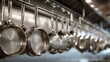 © Nurul - Shiny stainless steel pots and pans hang neatly from an overhead rack in a busy, well-equipped kitchen