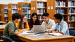 © JohnLee - Young university friends working on a collaborative assignment, sharing ideas and discussing upcoming lectures in a library.