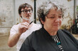 © Luciano Spinelli/Stocksy - Outdoor Haircut Against Weathered Wall