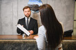 © Serhii - Hotel receptionist assisting customer during check in process