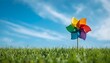 © aqsa - Colorful pinwheel spinning in a green grassy field under a bright blue sky