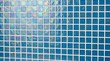 © ZaynR - Medium close-up shot of shimmering blue mosaic tiles forming a vibrant pattern in a modern setting