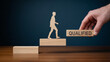 © Salman - Hand placing block with qualified text near wooden figure climbing stairs symbolizing career success with professional achievement advancement