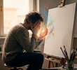 © Inna - Thoughtful artist sketching on canvas with glowing digital light, harmony between human imagination and technology concept [copy space]