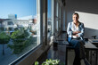 © Westend61 - Confident businesswoman sitting on desk in modern office