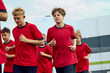 © master1305 - Youth soccer team jogging during outdoor training. Concept of football academy warmups, school sports programs, team fitness drills and youth sports ads.