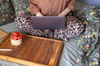 © Ina - Woman while sitting comfortably in bed and working on laptop with strawberries and notebook nearby. Remote work, freelance activity, online communication and flexible home office lifestyle concept.