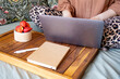 © Ina - Close up of woman working on laptop while sitting in bed with strawberries and notebook nearby. Remote work, freelance activity, online communication and flexible home office lifestyle concept.