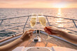 © Lustre Art Group  - Hands toasting champagne glasses on luxury yacht during sunset cruise. Concept of yacht charter advertising, luxury travel, honeymoon vacation and celebration campaign.