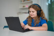 © Volodymyr - Meeting online helps remote classroom learning. Meeting with headphones supports clear call. Child joins meeting from home workspace. Video lesson makes meeting educational.
