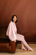 © Tania Cervian/Stocksy - Woman smiling in pink fashion outfit posing