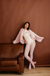 © Tania Cervian/Stocksy - Young woman posing in floral bodysuit and pink jacket