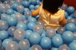 © umaruchan4678 - 青いボールプールで遊ぶ1歳の幼児の体の一部。屋内遊び場。