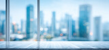 A blurred cityscape view from an empty room showcasing modern buildings in the background, capturing an urban outlook.