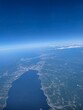 © HH - Scenic aerial view of scattered white cumulus clouds over a green landscape under a vast clear blue sky
