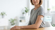 © Donquinotes - Woman with Continuous glucose monitoring device on arm sitting indoors