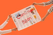 © Pixel-Shot - Hands holding a newspaper with coming soon text on orange background