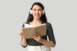© Pixel-Shot - Happy young woman with book and headphones listening to audiobook on white background