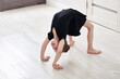 © Maria - Little girl doing backbend gymnastics exercise at home