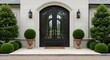 © Digitalogika Studio - Elegant entrance of a luxurious home with ornate black double doors and symmetrical green topiary landscaping.