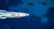 © moofushi - Aerial overhead view of a modern luxury yacht sailing over the blue ocean with copy space