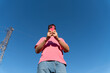 © Alba Vitta Studio/Stocksy - Man using phone against blue sky
