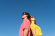 © Alba Vitta Studio/Stocksy - Couple Stands Back to Back Wearing Sunglasses Under Clear Sky