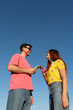 © Alba Vitta Studio/Stocksy - Couple with phones Enjoys Outdoors blue sky