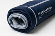 © Steve - A rolled-up surf shirt revealing its technical fabric interior on a plain surface.