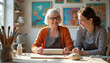 © miss irine - Two women artists shape clay with rolling pin at table in bright art studio. Older woman smiles, younger woman looks down at work, focused. Paintings on wall.