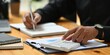 © Muhammad - Closeup of a businessman calculating financial data and taking notes