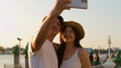© blueringmedia - Young Asian Couple Taking a Selfie by the Bangkok Riverside at Sunset