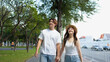 © blueringmedia - Young Asian Couple Holding Hands While Walking Near Historic Temple Walls